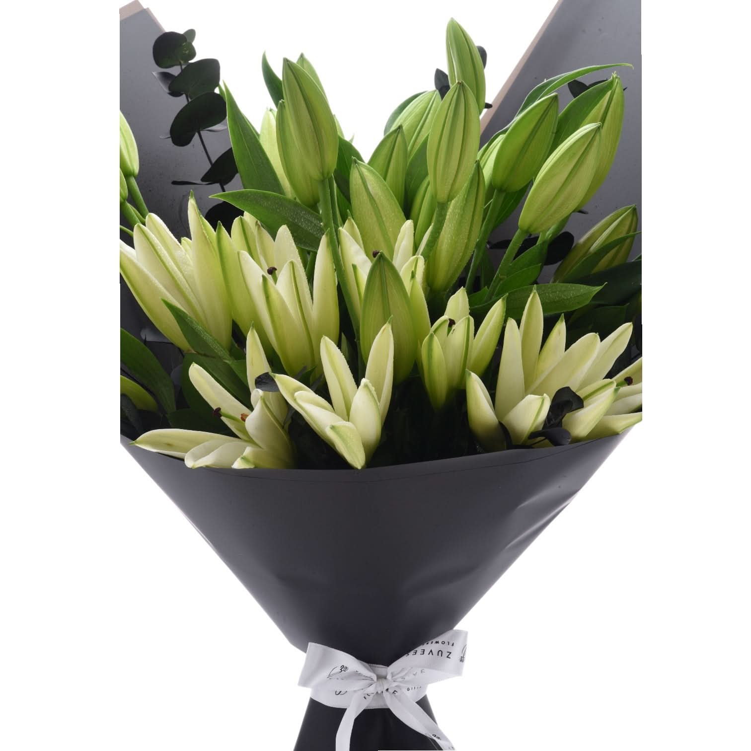Elegant green-and-white lily bouquet wrapped in matte black paper with white bow.