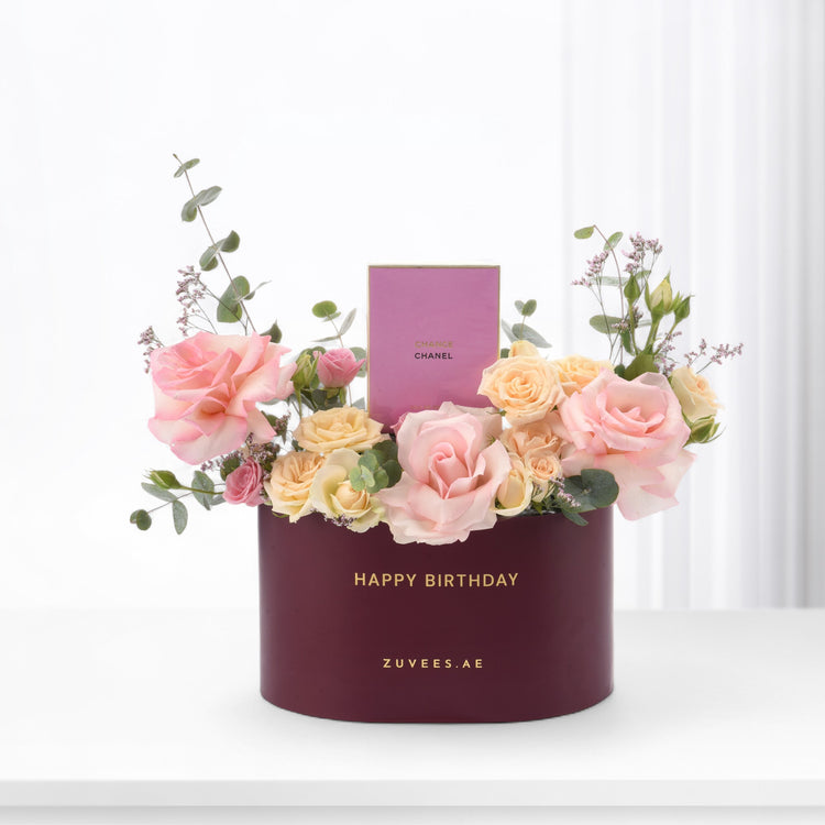 Elegant burgundy box holds blush roses, eucalyptus, and Chanel perfume for birthday.