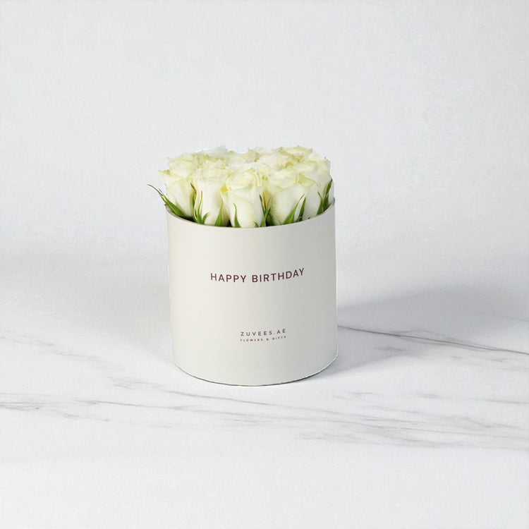 White roses in elegant cream box, "Happy Birthday" text, marble background, minimalist luxury gift.
