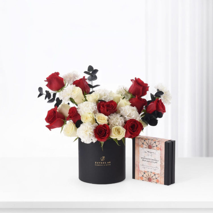 Elegant black box with red and white roses from, paired with fine chocolates of Zuvees Luxe Chocolate, Mirzam and Lakrids — a refined romantic gift.