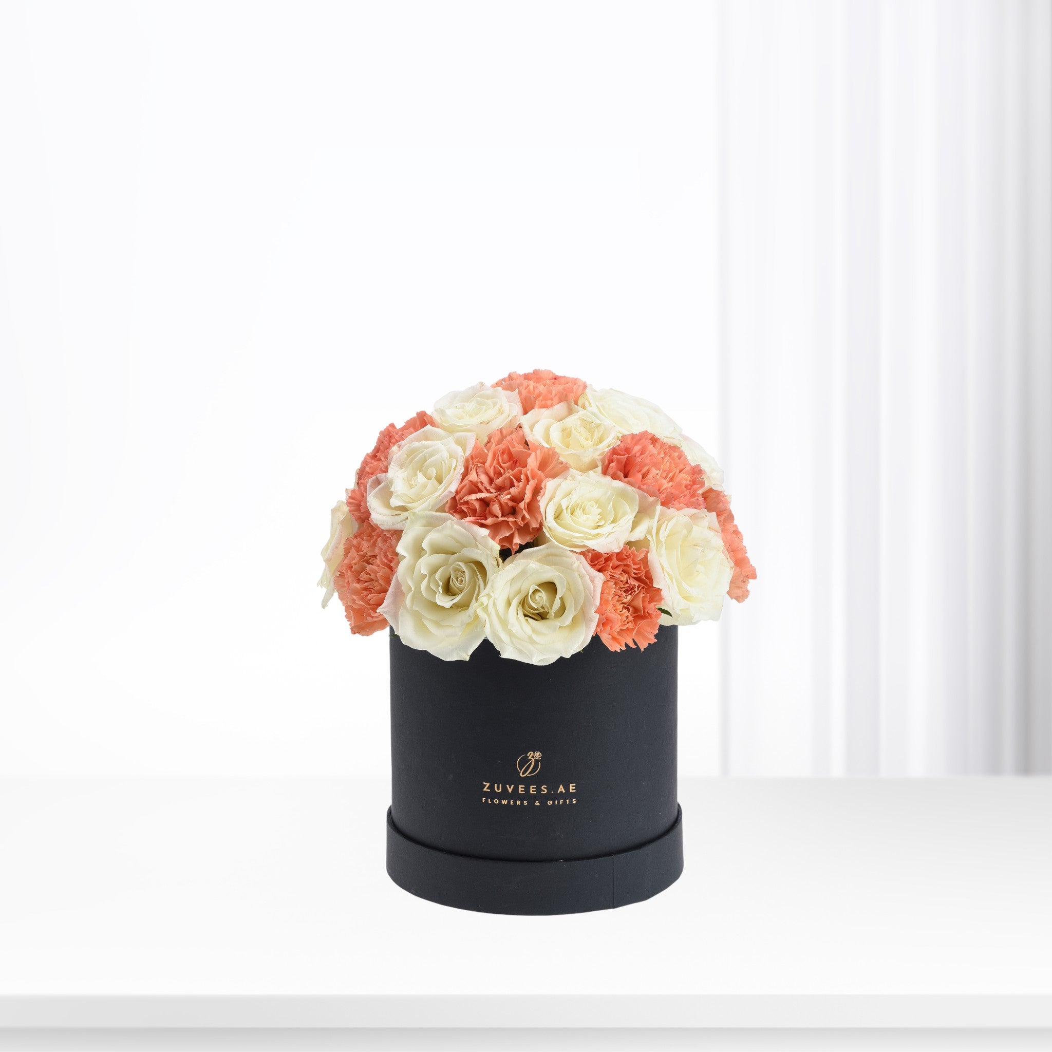 Elegant coral and ivory roses & carnations in matte black box.