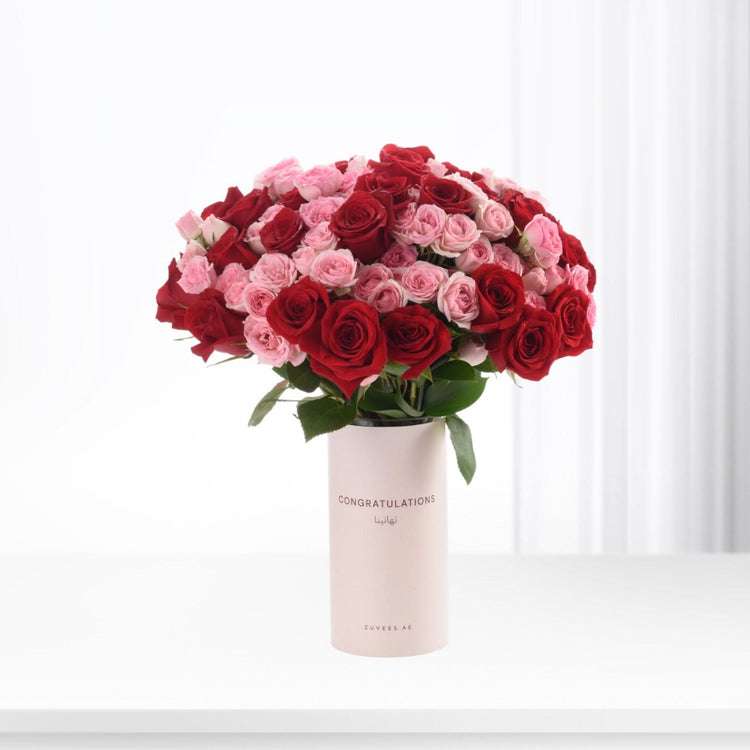Vibrant red and pink roses in minimalist vase with "Congratulations" text.