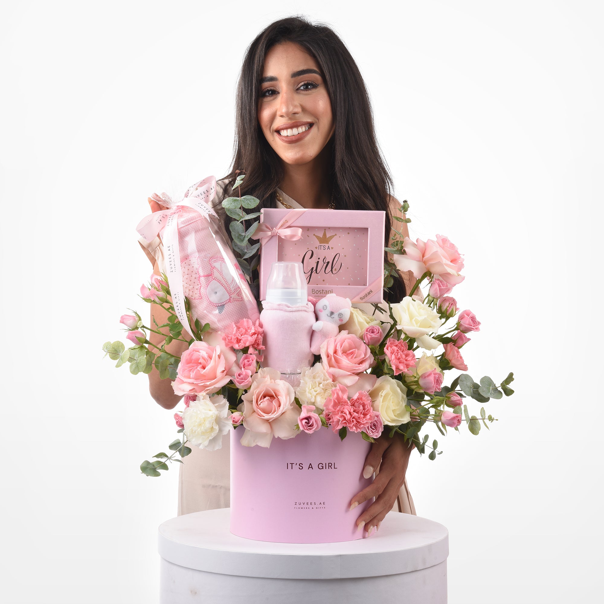 Pink floral baby shower gift basket with plush toys and framed “It’s a Girl” message.