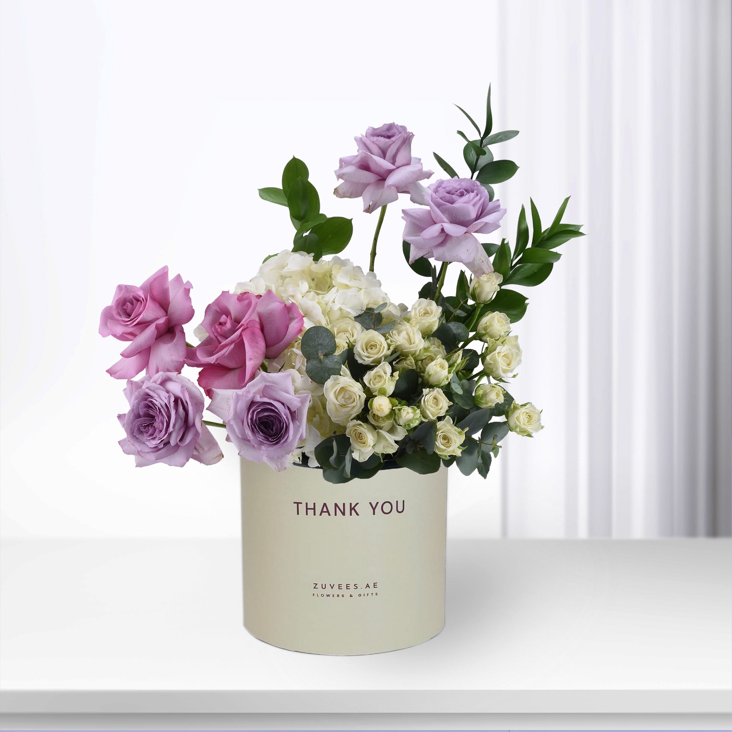 Elegant lavender and white rose bouquet in cream “Thank You” cylinder vase.