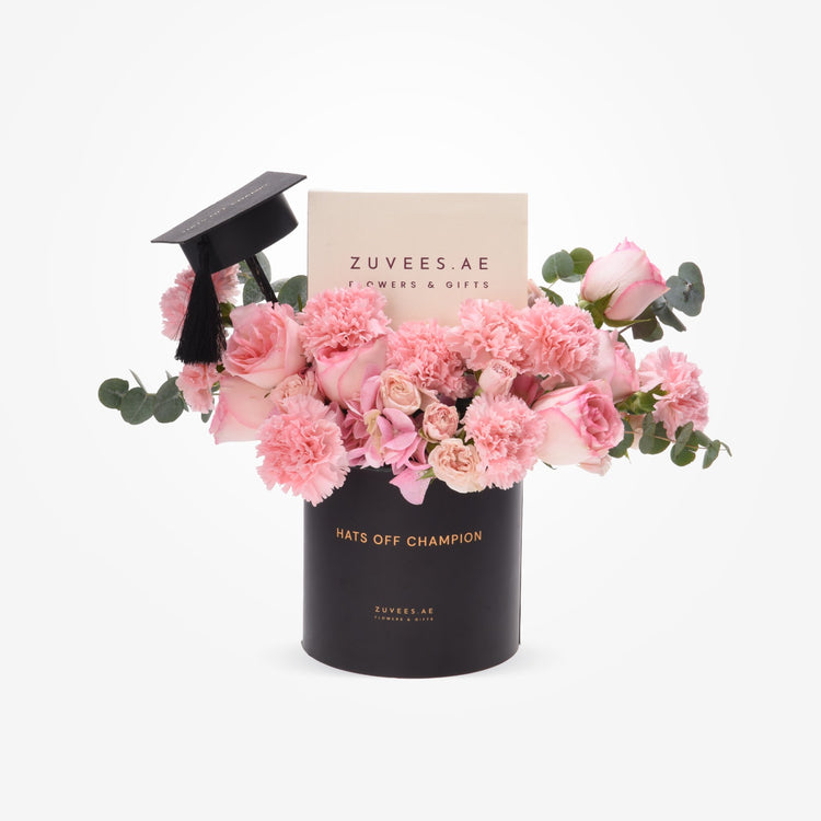 Pink roses and carnations in black graduation-themed vase with tassel.