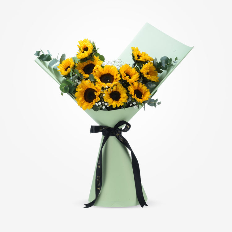 Vibrant sunflowers in mint wrap, accented with eucalyptus and baby’s breath, tied with black ribbon.