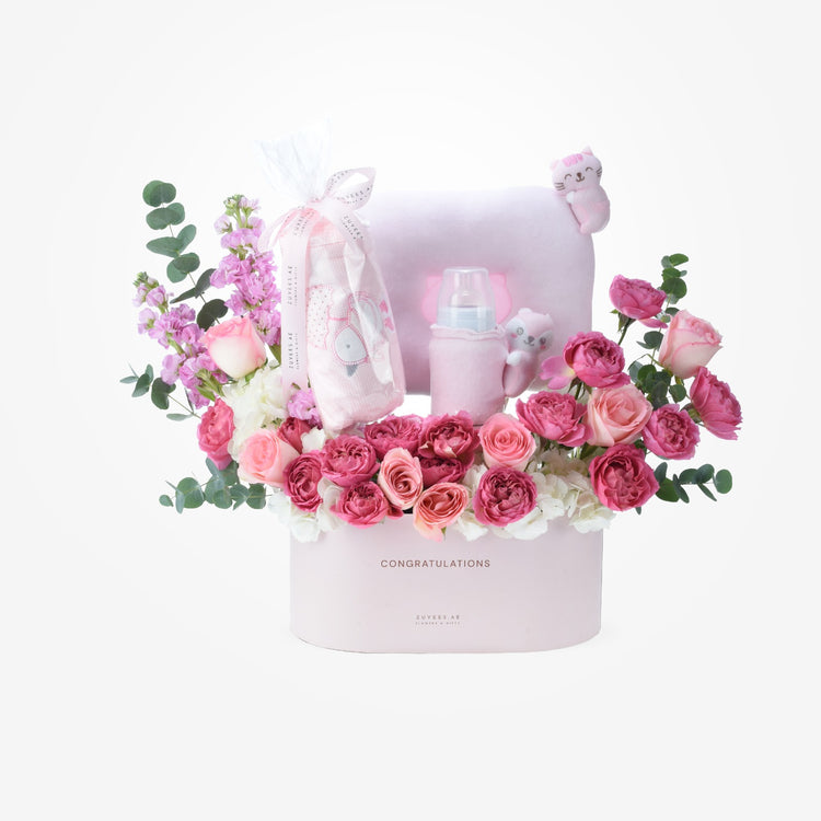 Pink floral baby gift basket with plush toys and bottles.