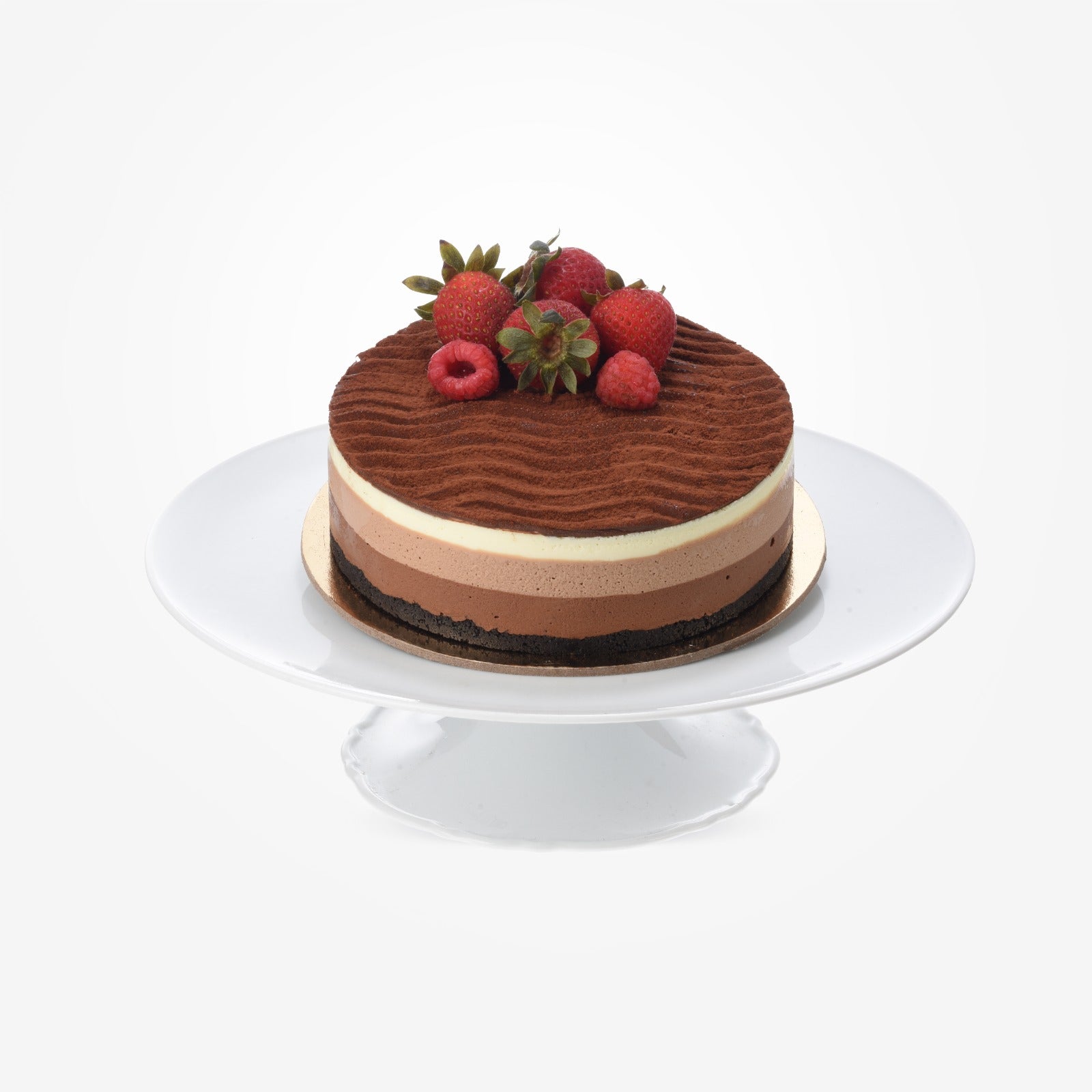 Layered chocolate cake topped with fresh strawberries and raspberries.