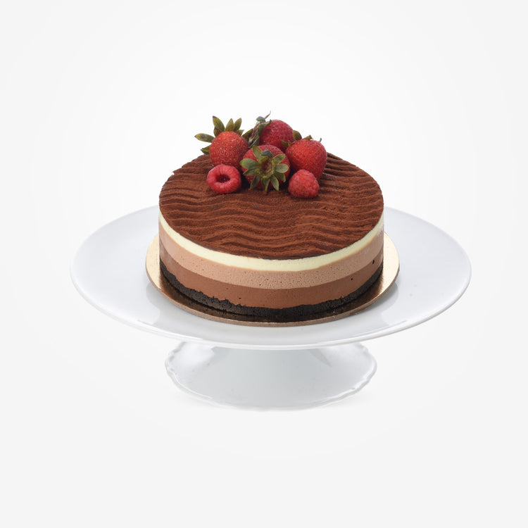 Layered chocolate cake topped with fresh strawberries and raspberries.