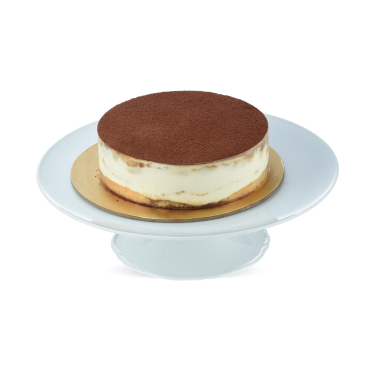 Rich chocolate-topped tiramisu cake on elegant white pedestal stand.