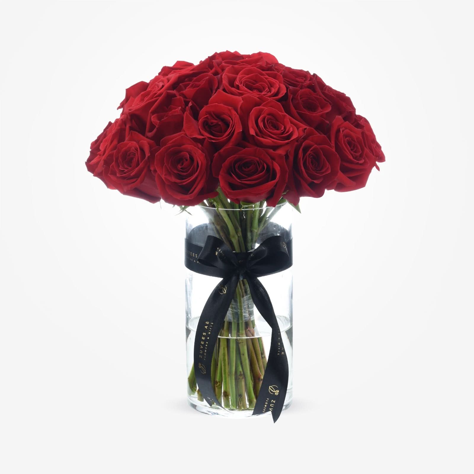 Vibrant red roses in clear glass vase, elegantly tied with black ribbon.