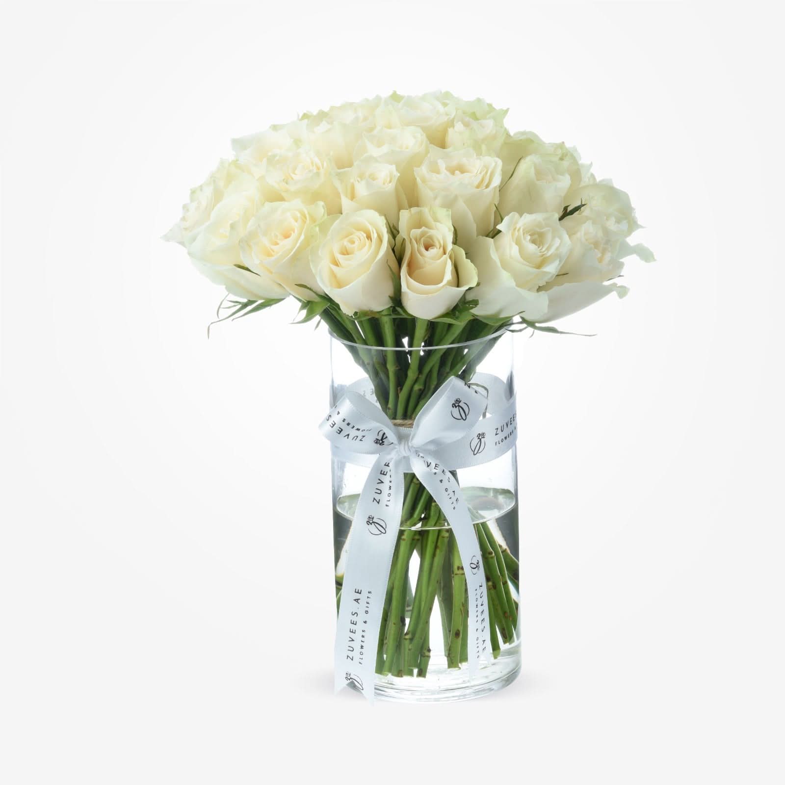 Elegant white roses in clear vase, tied with branded white ribbon.