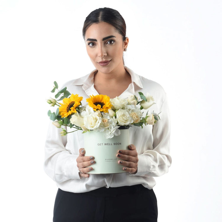 White box holds vibrant sunflowers and white roses for get-well-soon gift.