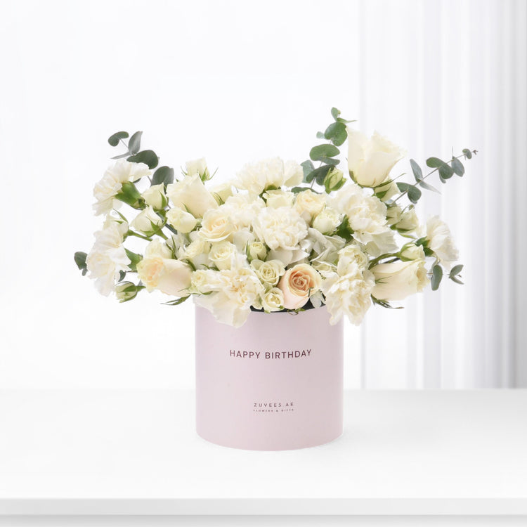 Elegant white roses and carnations in blush pink "Happy Birthday" gift box, accented with eucalyptus.