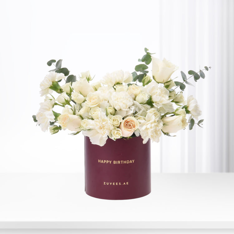 Elegant white roses and carnations in deep burgundy "Happy Birthday" box, accented with eucalyptus.