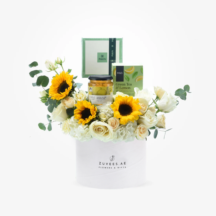 White roses, sunflowers, eucalyptus, tea, marmalade in elegant white gift box.