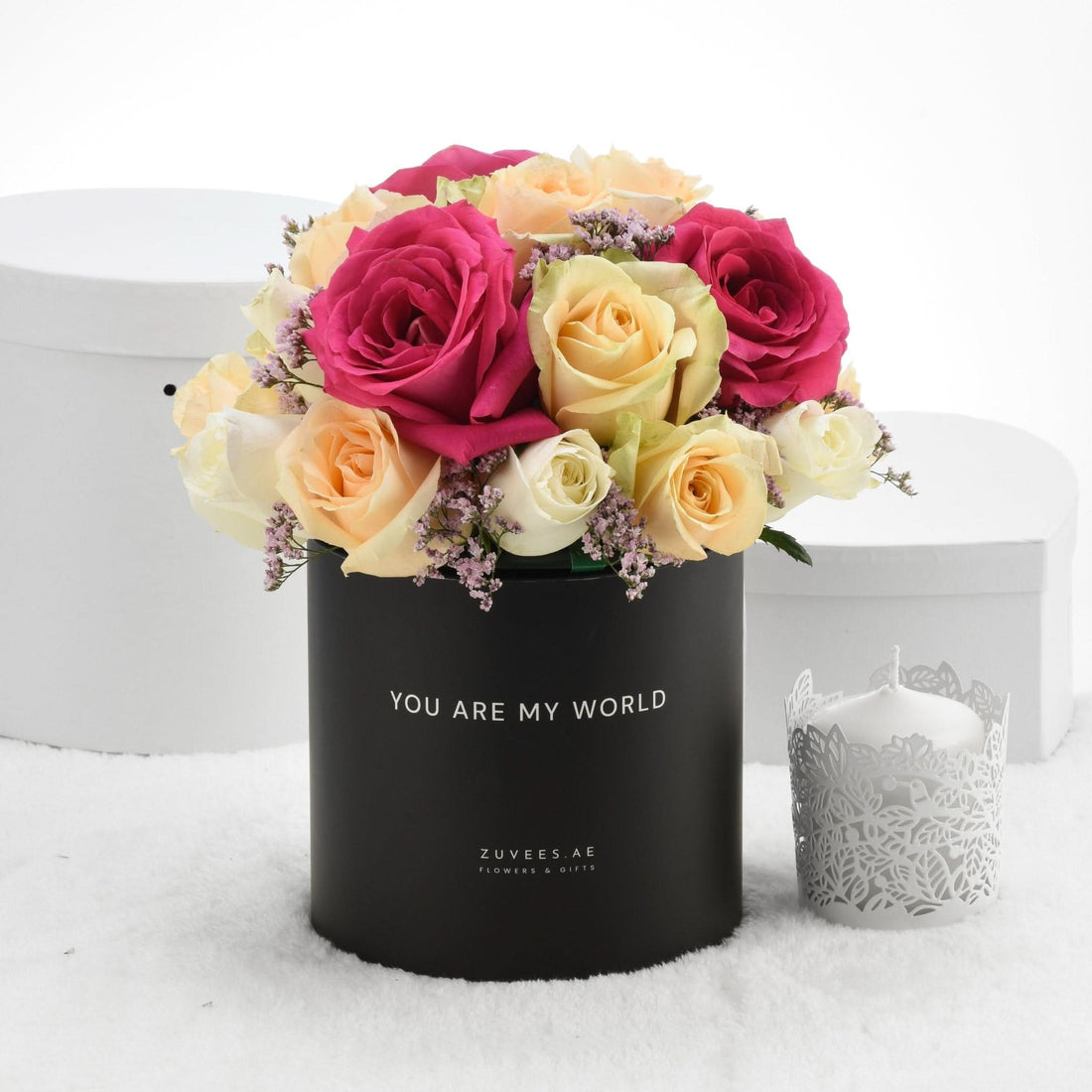 Vibrant pink, yellow, and white roses in black box with "You Are My World" text.