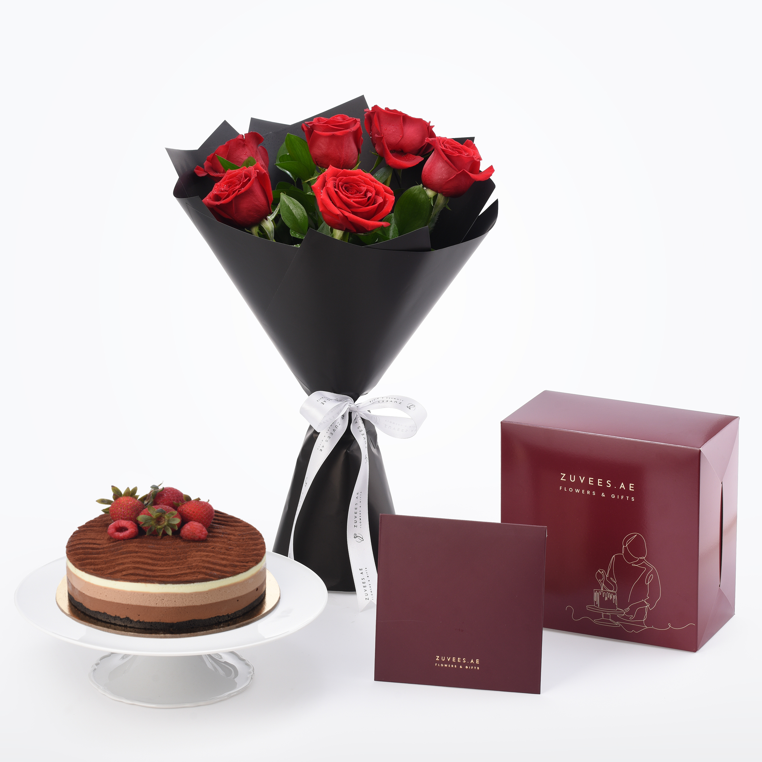 Six red roses in black wrap, chocolate cake with berries, ZUVEES.AE gift boxes.