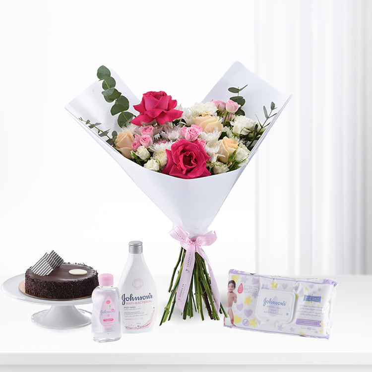 Vibrant pink, white, and peach roses in white wrap, paired with chocolate cake and Johnson’s baby essentials.