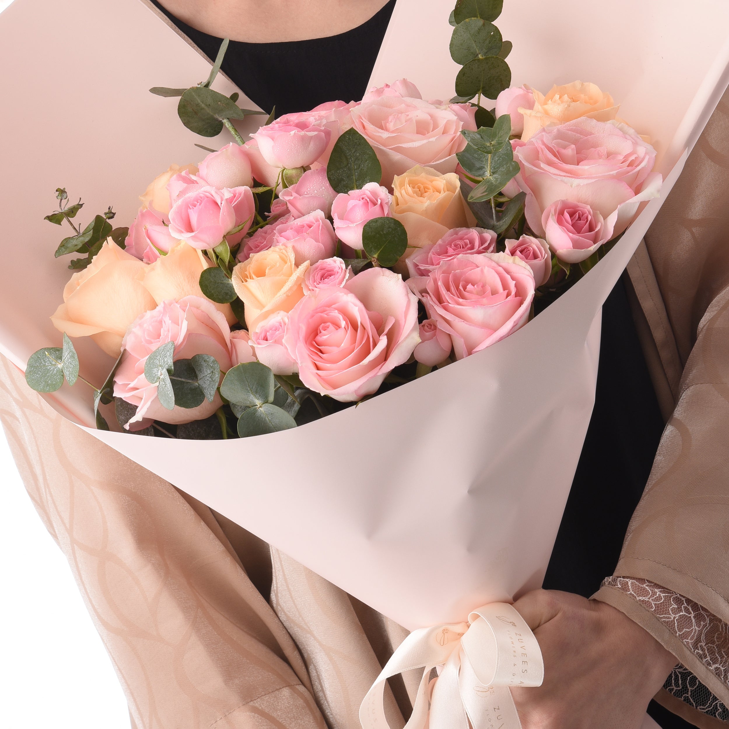 Soft pink and peach roses with eucalyptus, elegantly wrapped in blush paper.