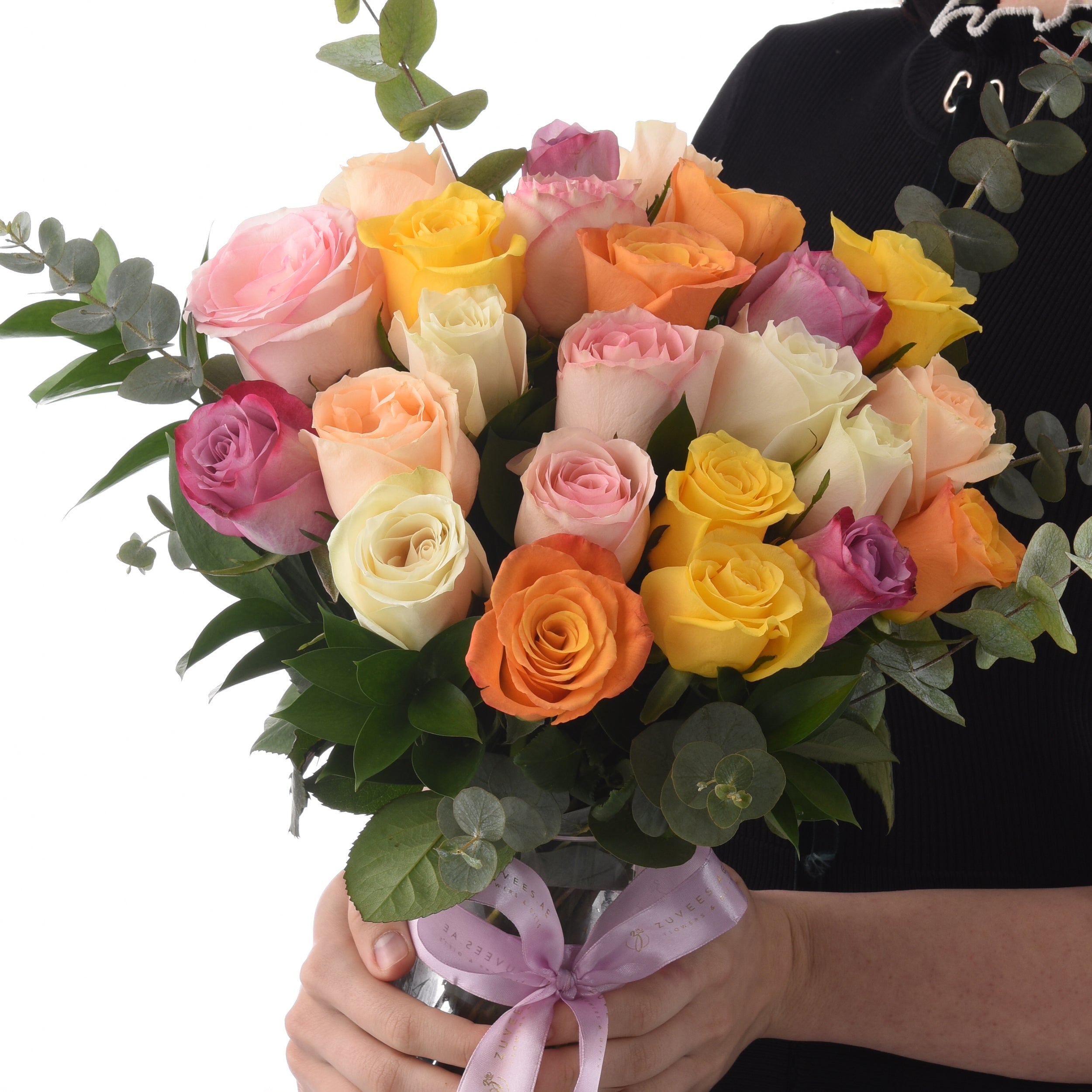 Vibrant multi-colored roses in lush bouquet, tied with lavender ribbon.