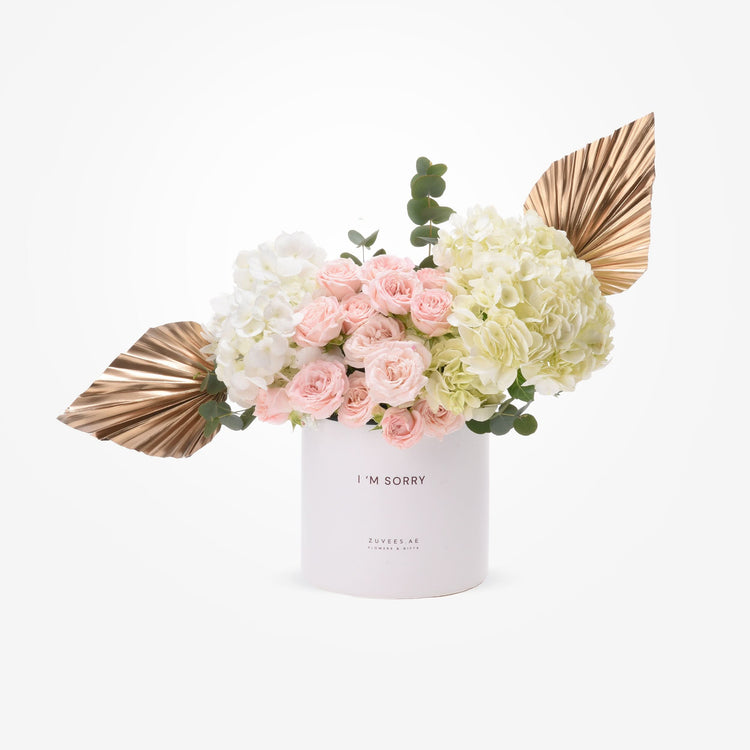 Soft pink roses and hydrangeas in white cylinder with “I&