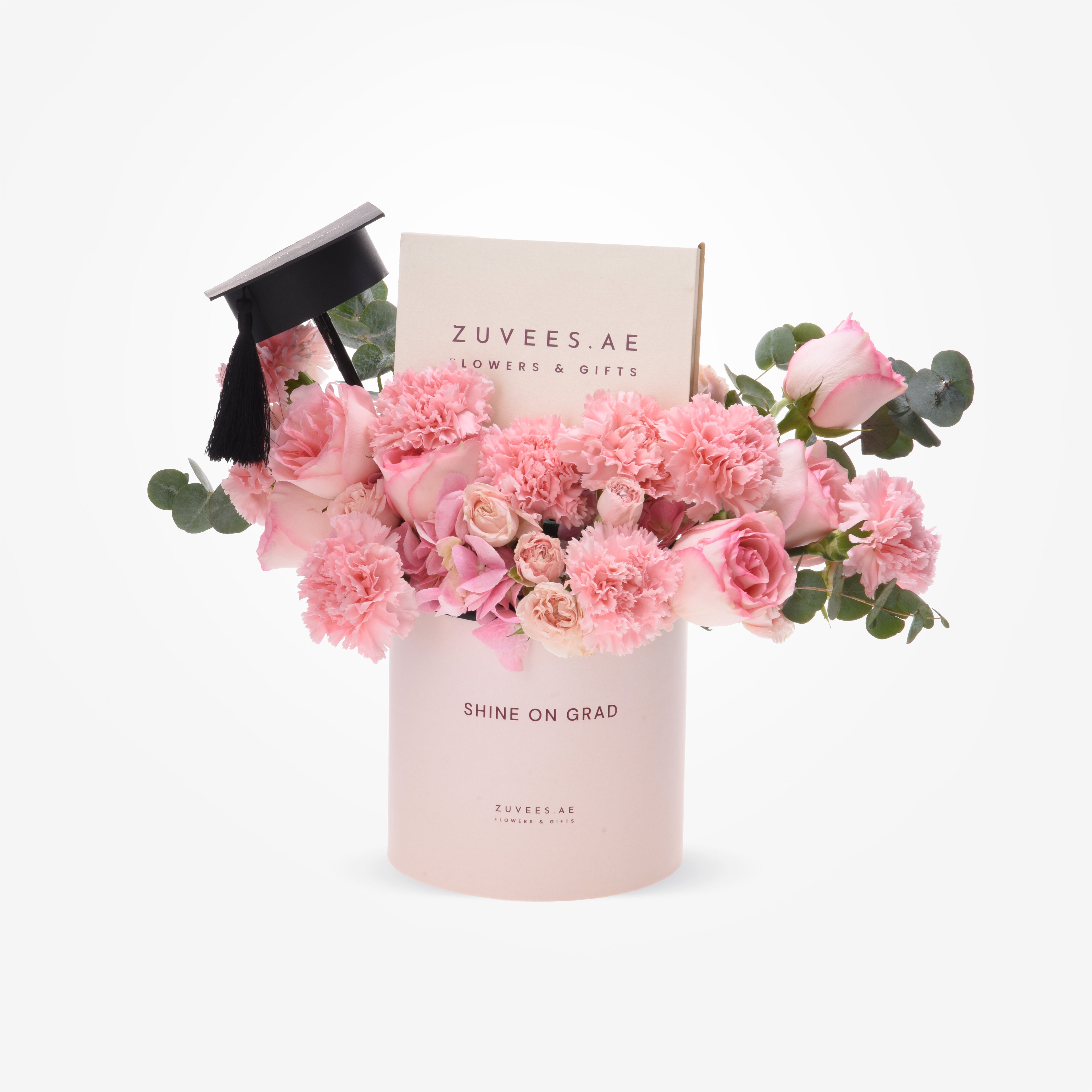 Soft pink roses and carnations in a "Shine On Grad" cylinder, topped with a graduation cap.