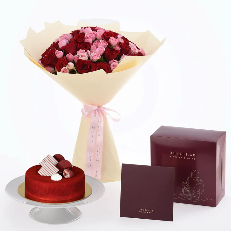 Luxurious red and pink rose bouquet paired with velvet red cake in elegant maroon gift box.