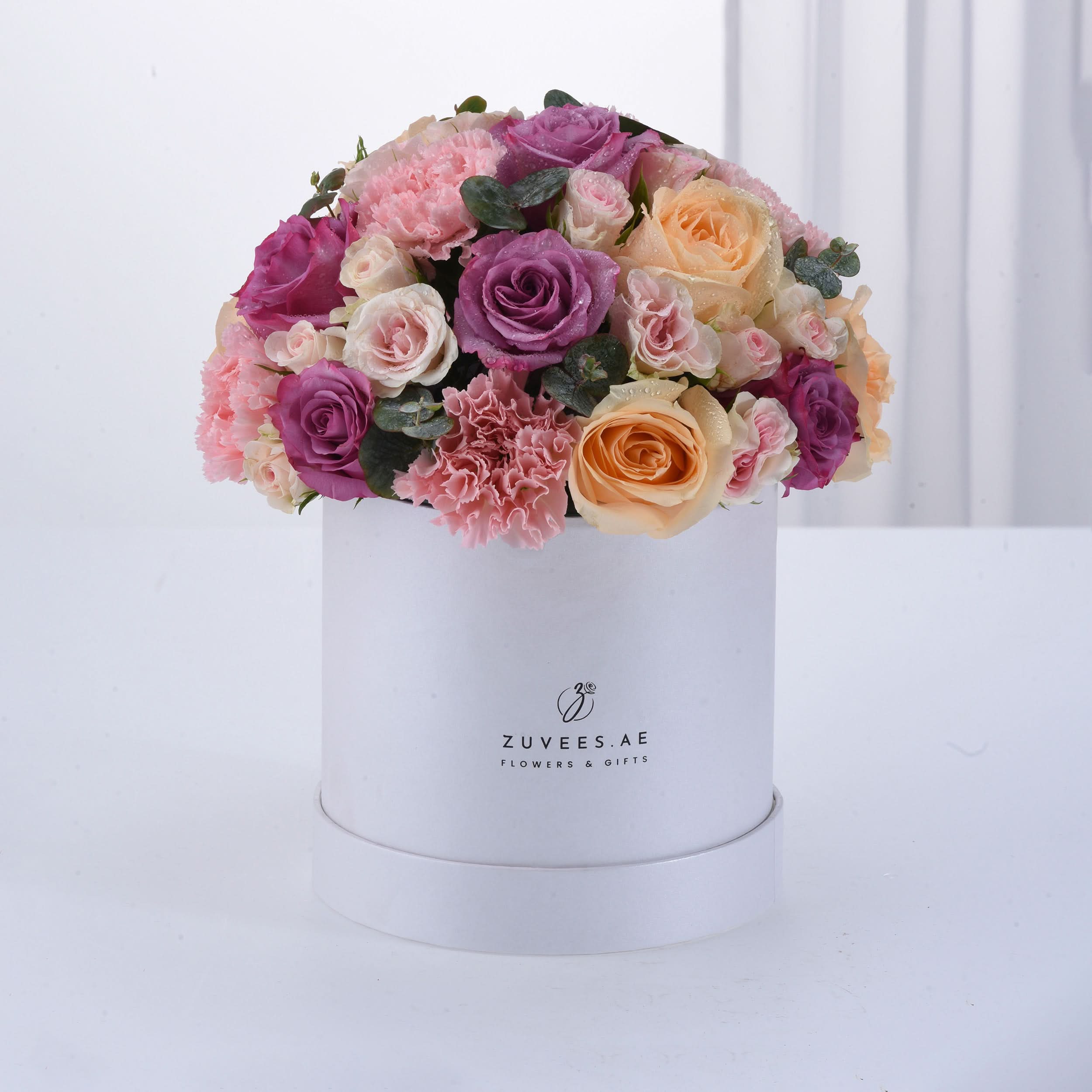 Elegant pastel roses and carnations in white box, ZUVEES.AE branding.