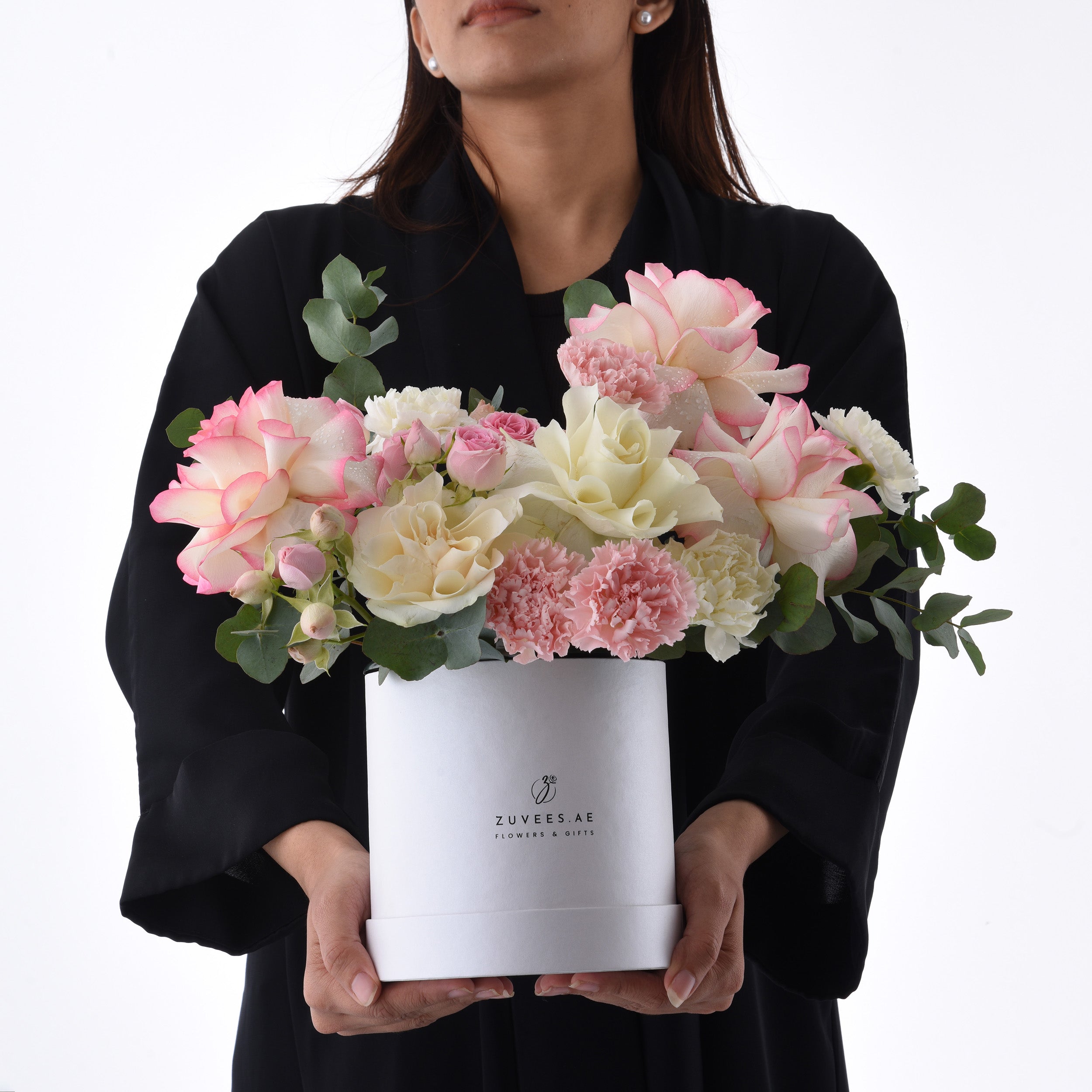 Elegant white box holds blush pink and cream roses, carnations, and eucalyptus.
