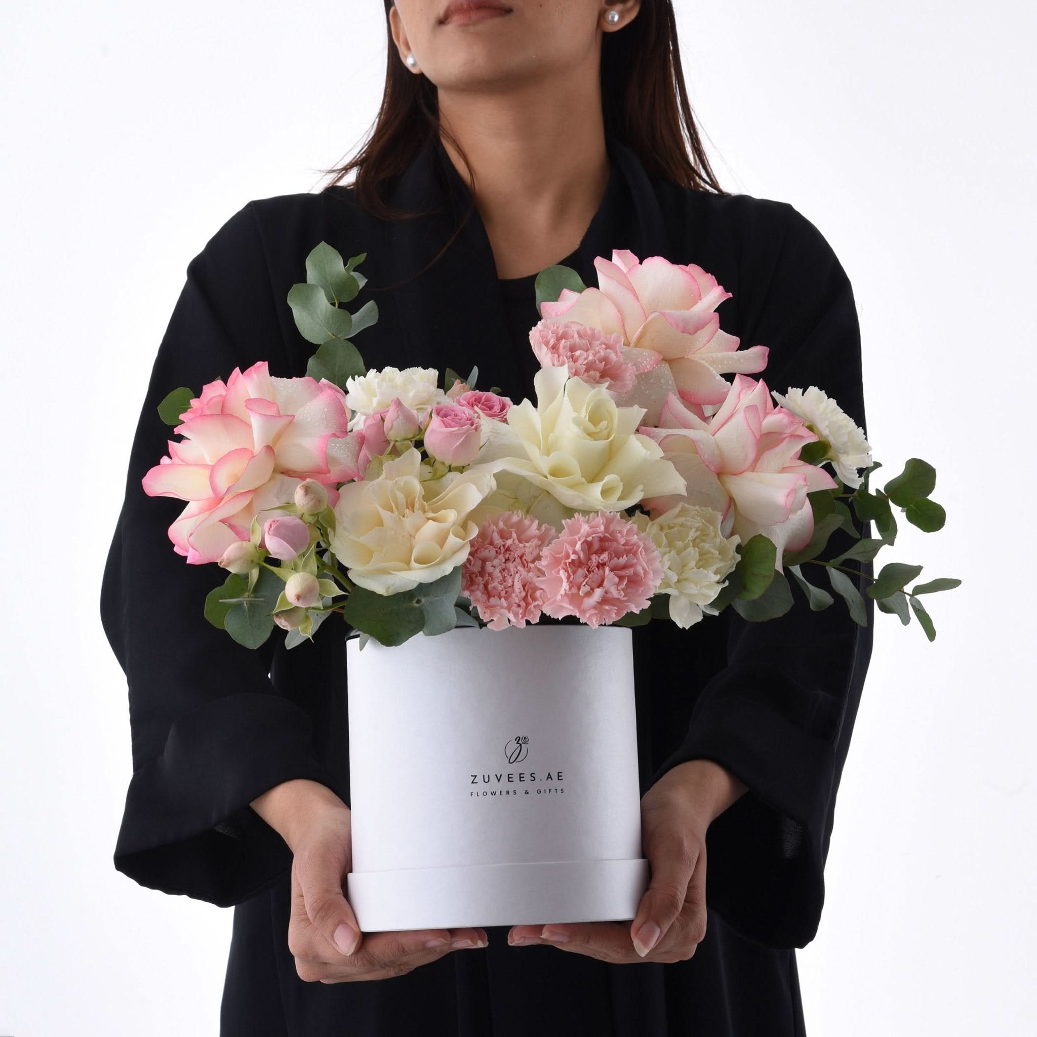 Elegant white box holds blush pink roses, cream peonies, and soft pink carnations.