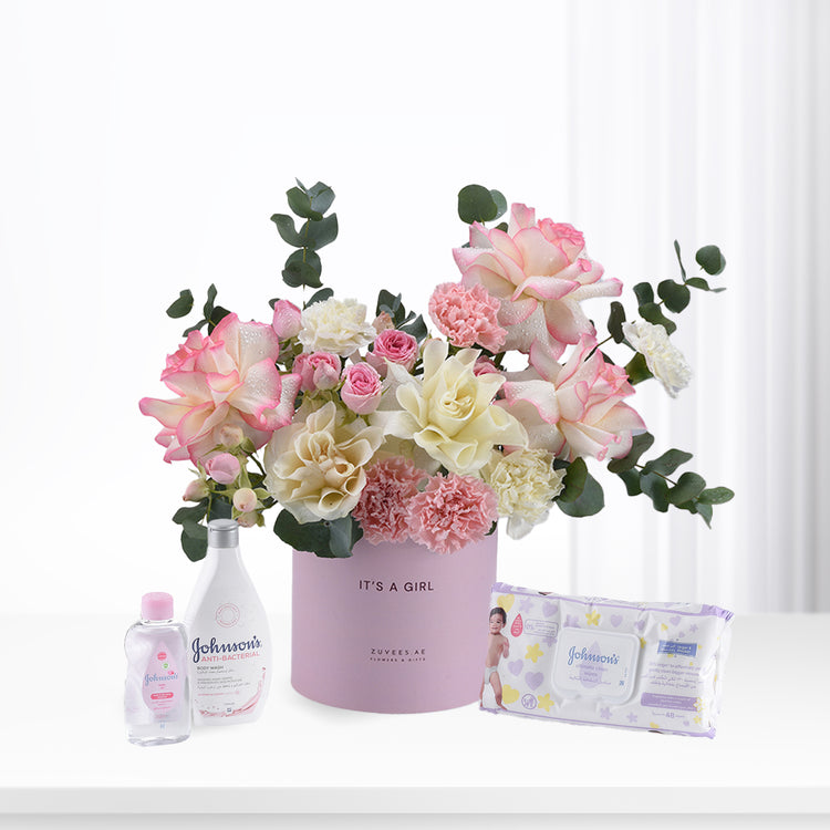 Pink roses and carnations in lavender box with baby essentials.