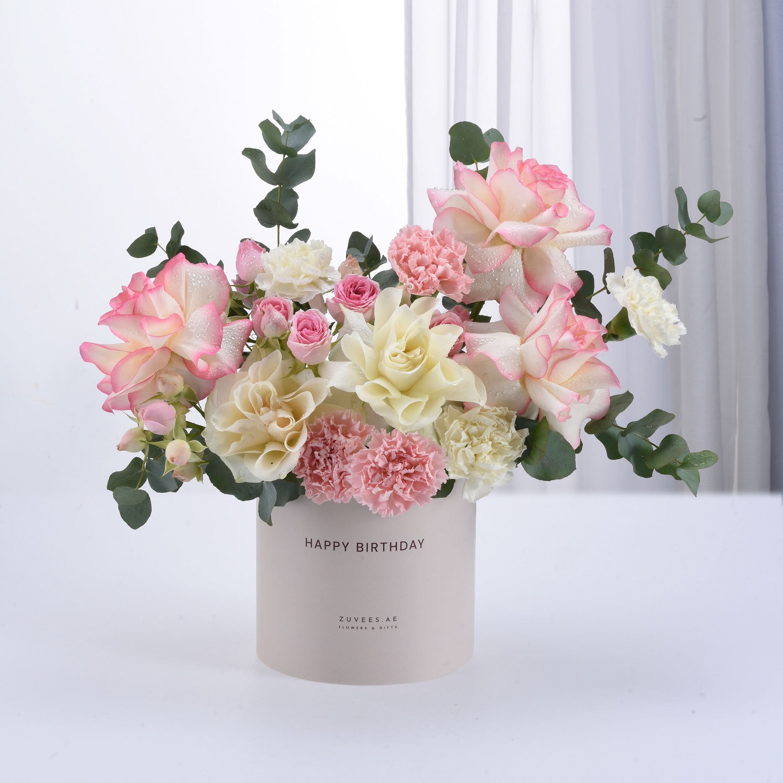 Pastel pink and cream roses with carnations in a "Happy Birthday" cylinder vase.
