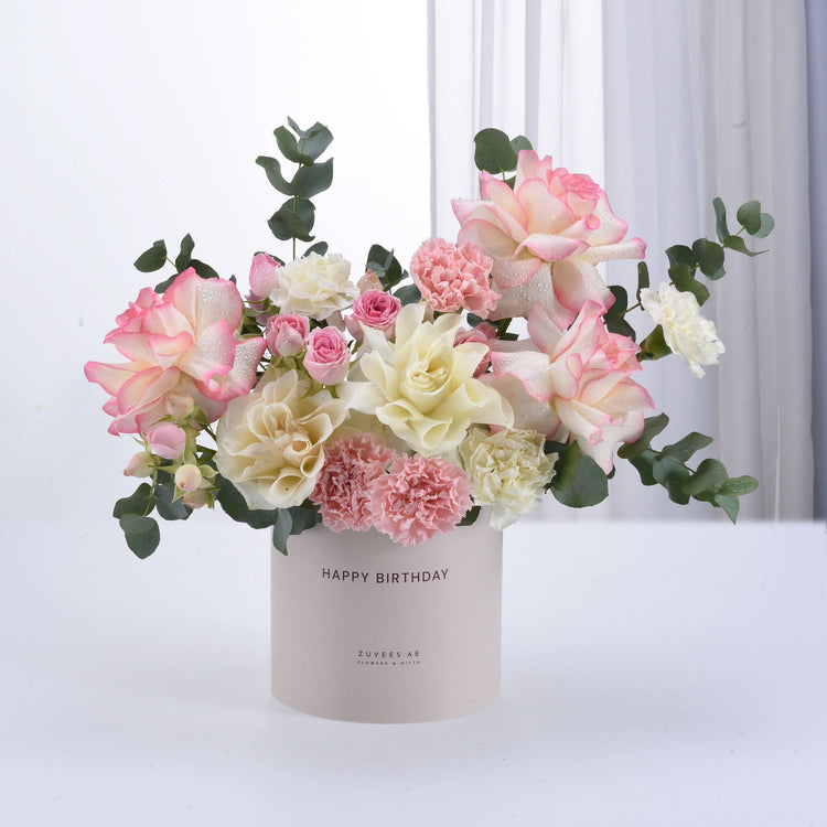 Pastel pink and cream roses with carnations in a "Happy Birthday" cylinder vase.