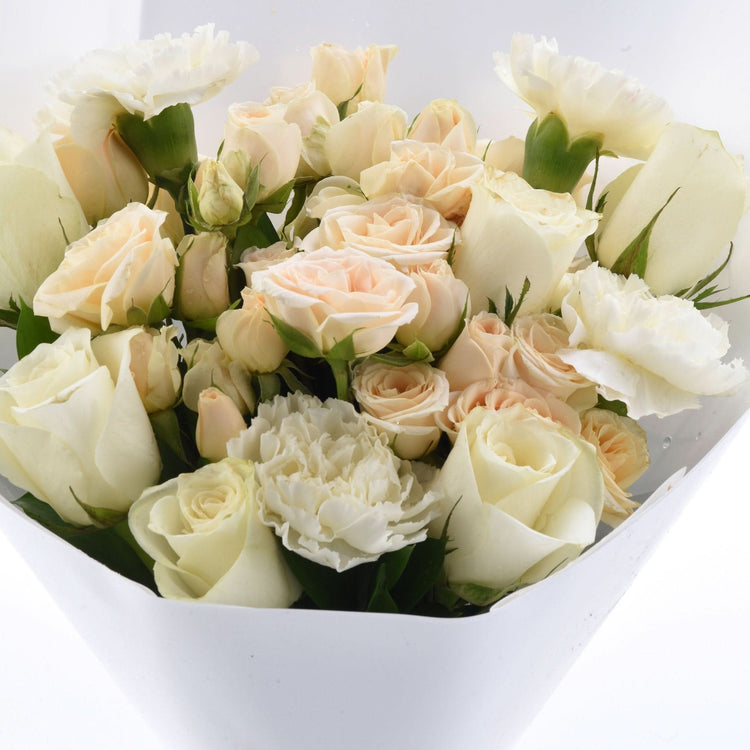 Soft ivory roses and carnations in elegant white wrap.