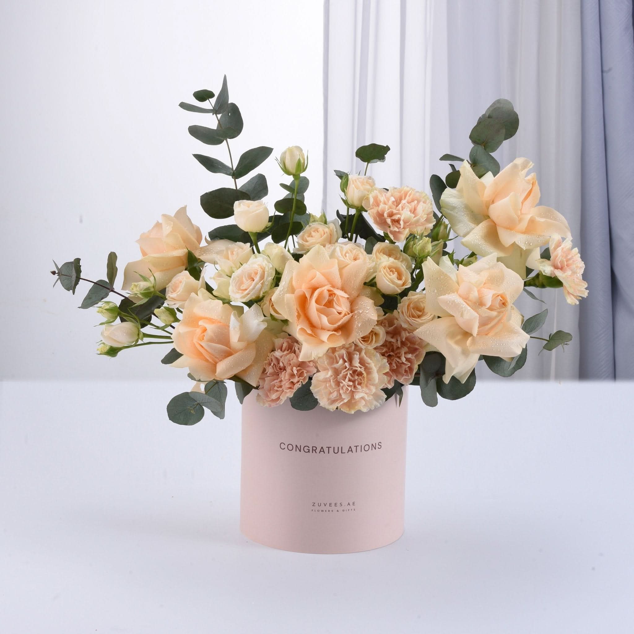 Soft peach roses and carnations in pink "Congratulations" cylinder vase.
