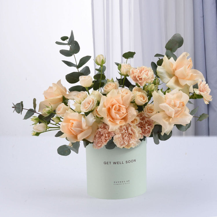Pastel peach roses and carnations in mint "Get Well Soon" gift box.