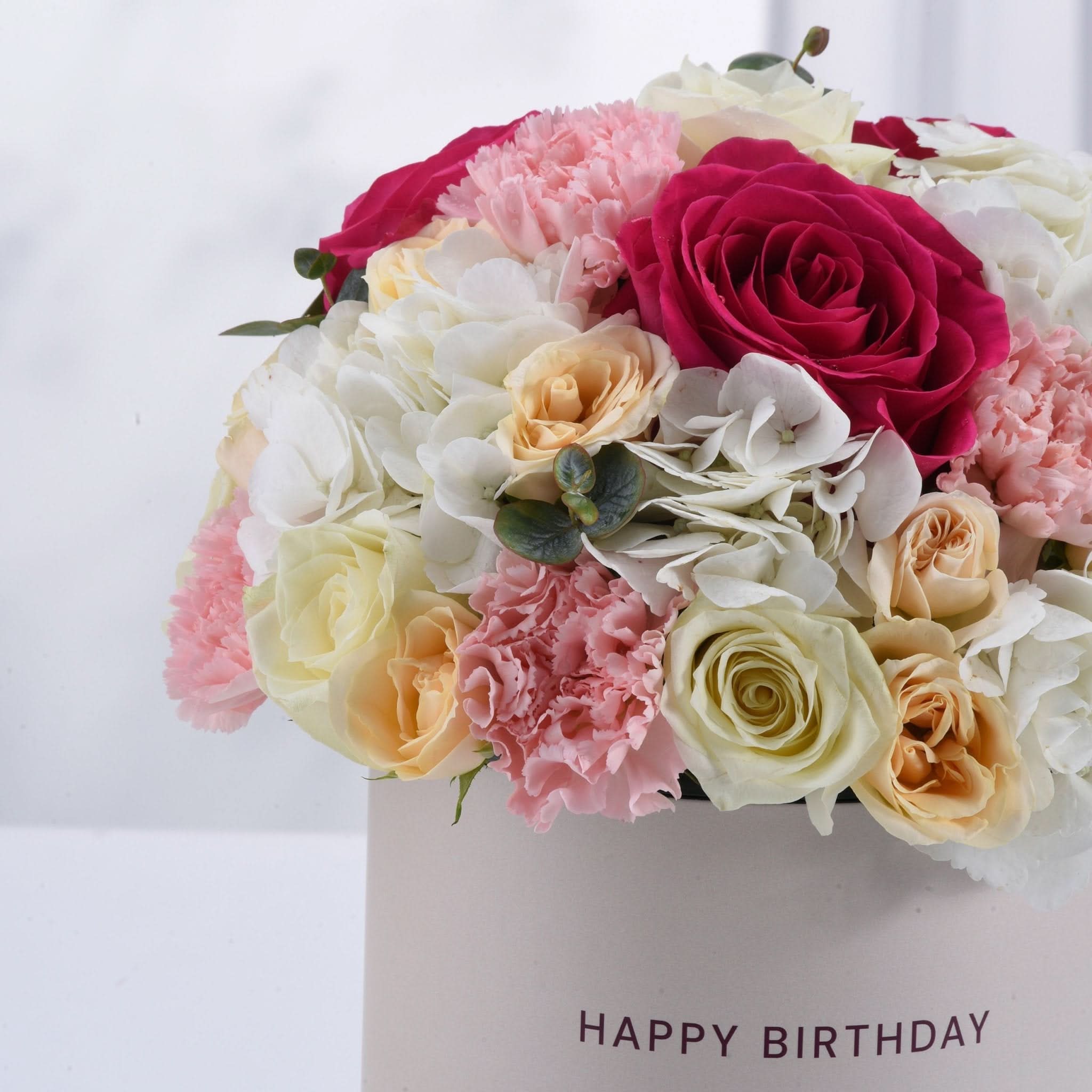 Vibrant pink, white, and peach roses & carnations in "Happy Birthday" box.