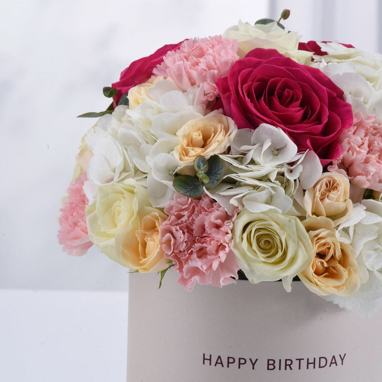 Vibrant pink, white, and peach roses & carnations in "Happy Birthday" box.