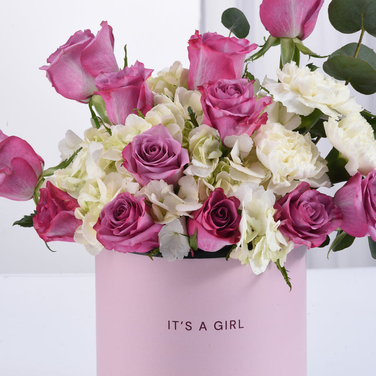 Pink and white roses, hydrangeas, and eucalyptus in a "It&