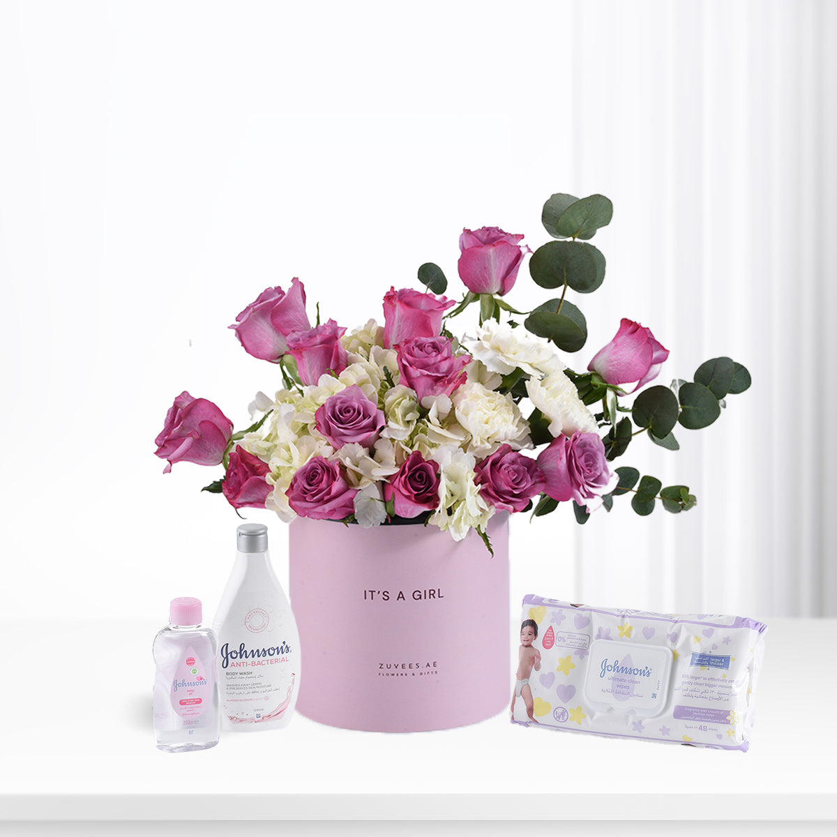 Pink roses and eucalyptus in “It’s a Girl” box with Johnson’s baby essentials.