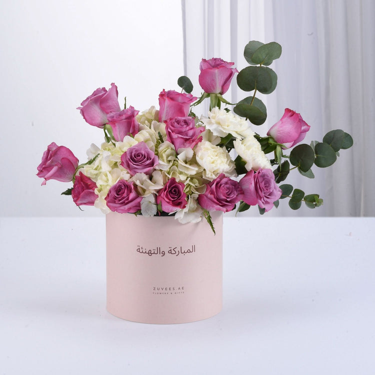 Pink roses and white hydrangeas in blush box with Arabic greeting.