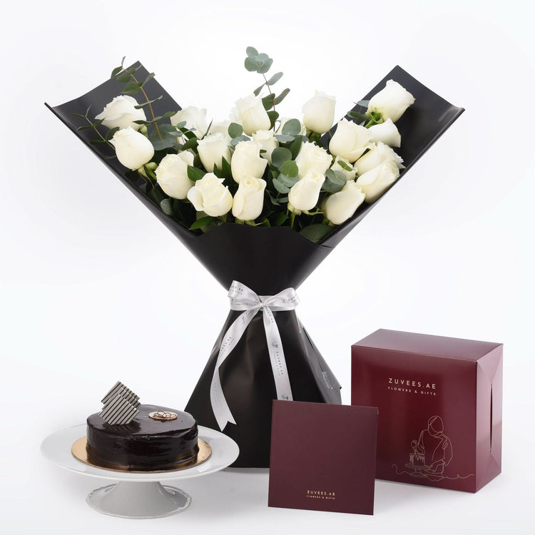 Elegant white roses in black wrap, paired with chocolate cake and branded gift boxes.