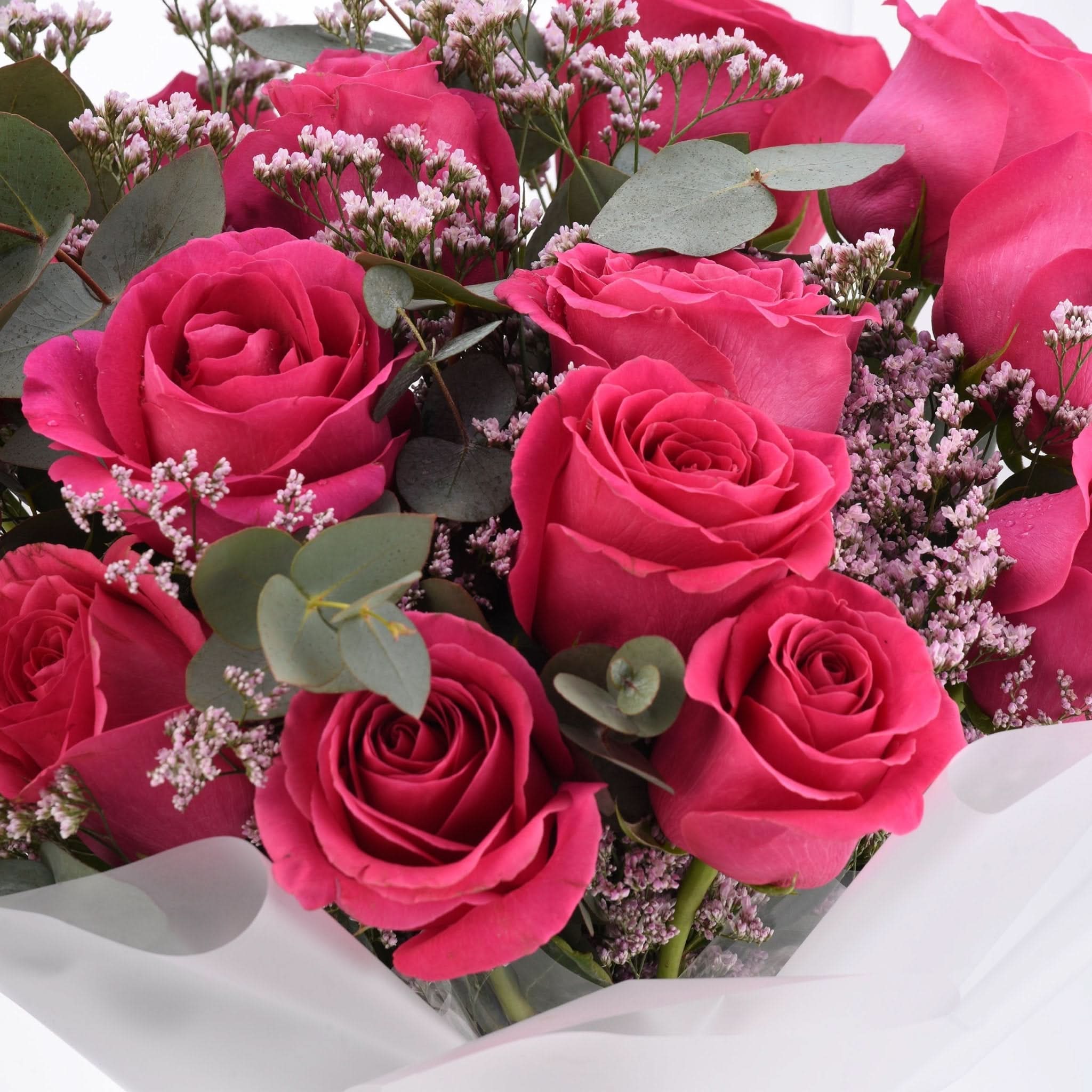 Vibrant pink roses, baby’s breath, and eucalyptus in crisp white wrap.