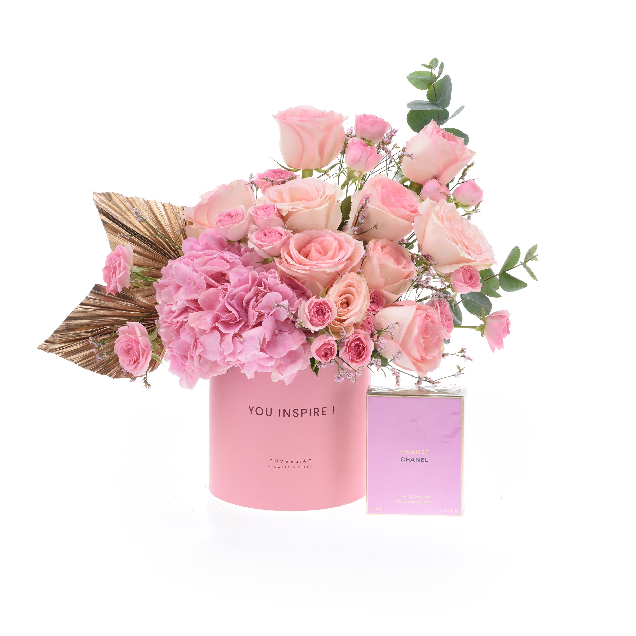 Pink roses and hydrangeas in a branded pink vase with Chanel perfume.