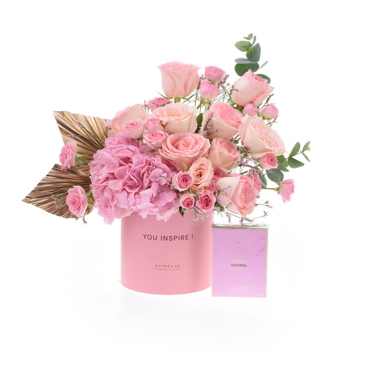 Pink roses and hydrangeas in a branded pink vase with Chanel perfume.