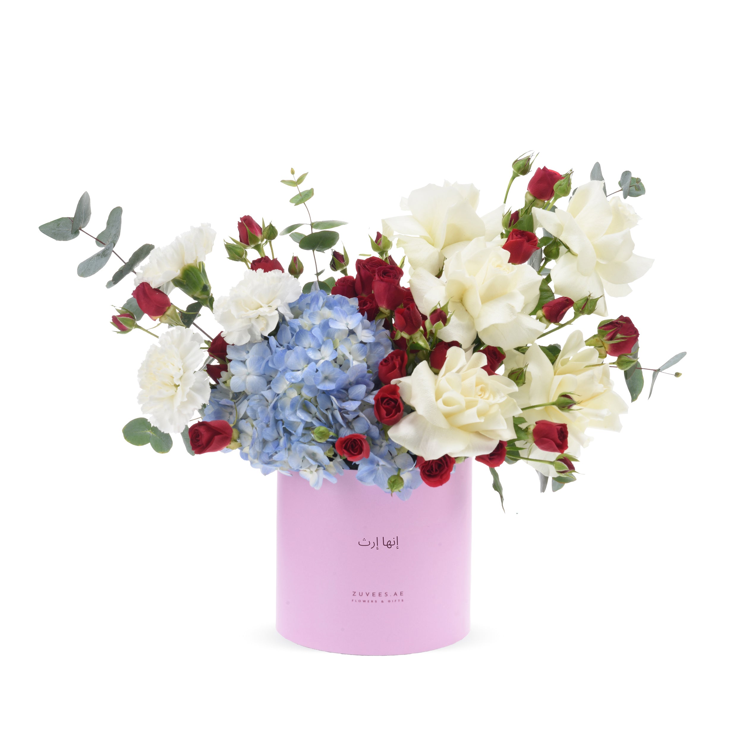 Pink cylinder vase holds red, white roses and blue hydrangeas with eucalyptus.