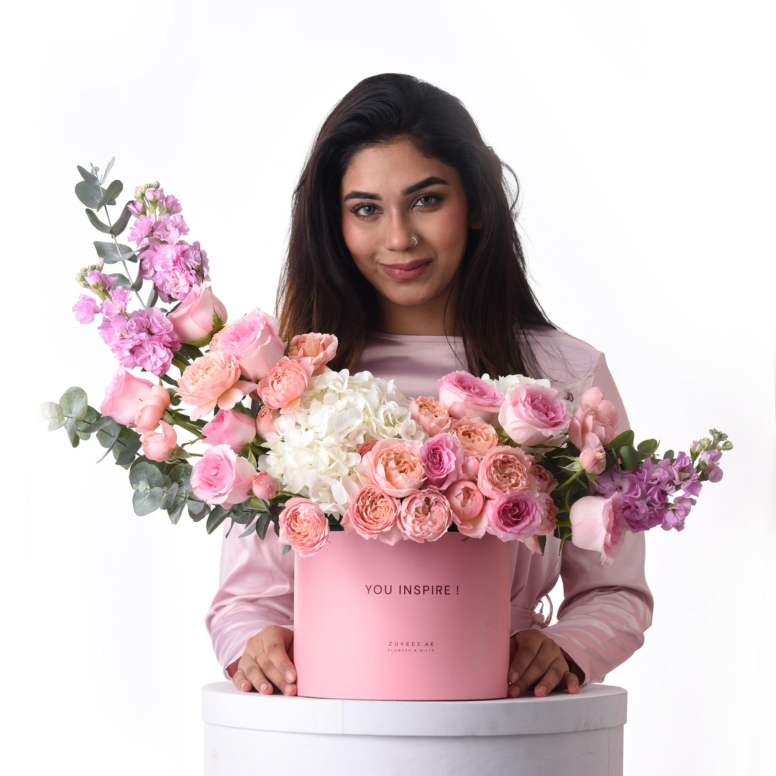Pink box overflowing with roses, hydrangeas, and eucalyptus—“You Inspire!” message.