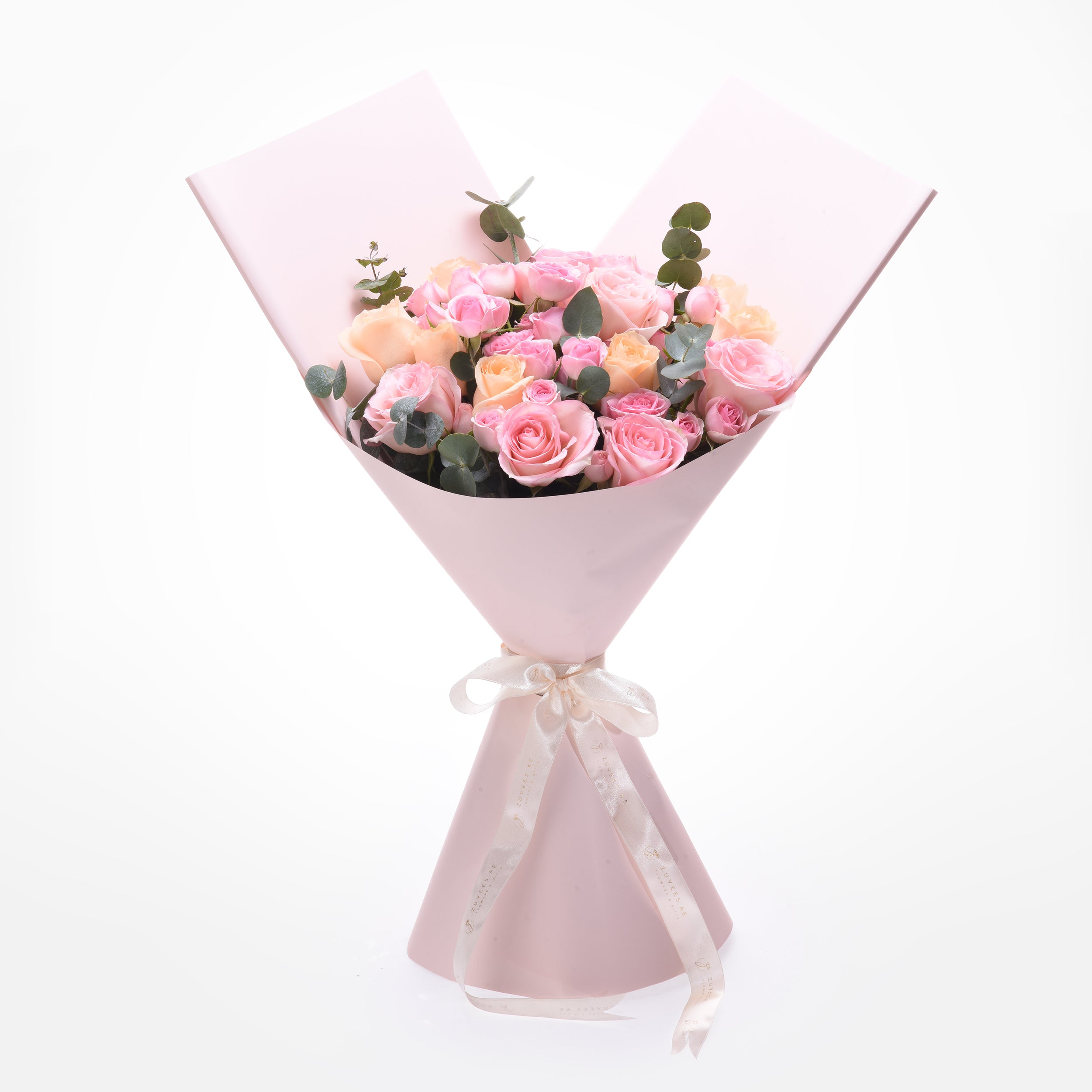 Soft pink roses and eucalyptus wrapped in matching paper with elegant cream ribbon.
