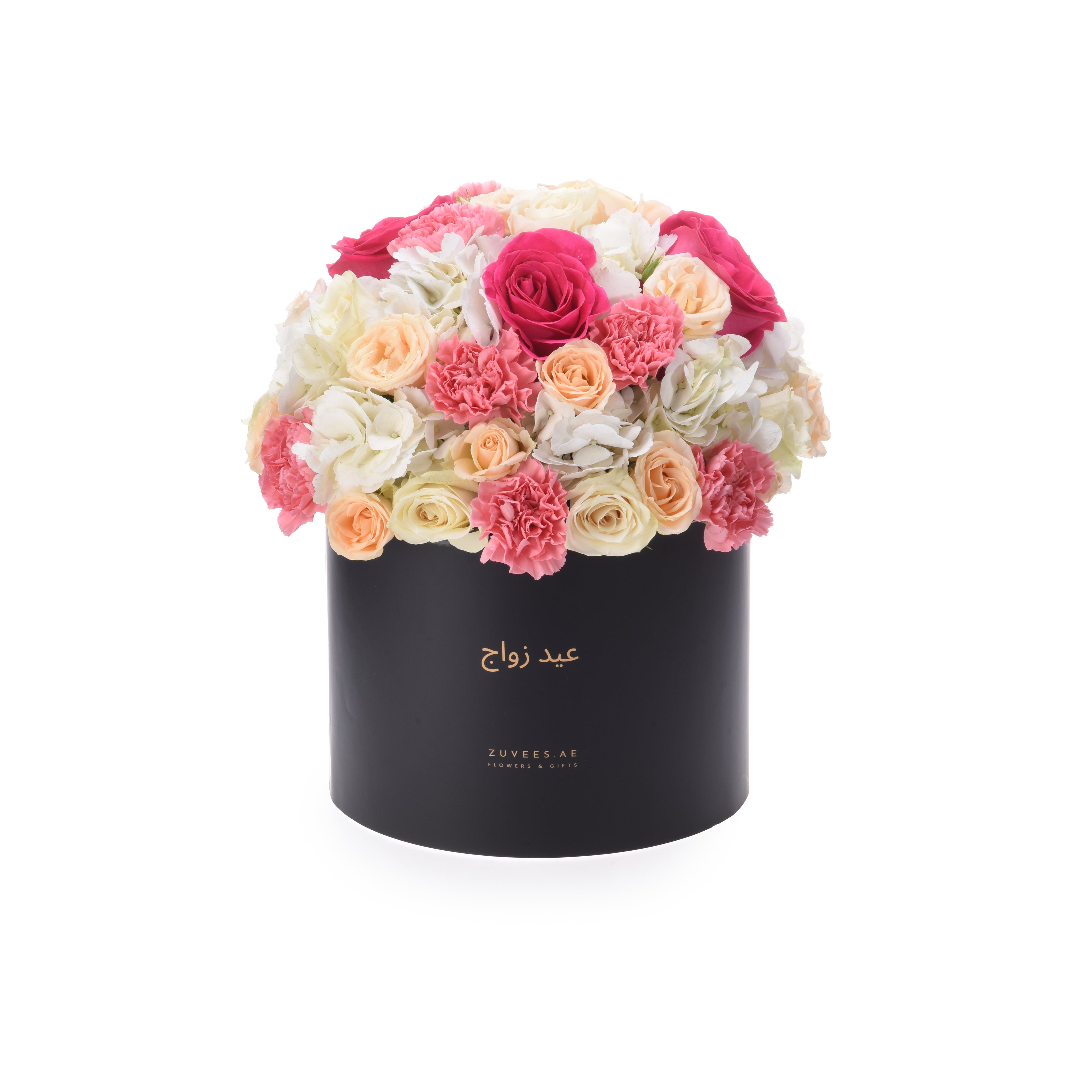 Black cylindrical box overflowing with vibrant pink, peach, and white roses and carnations.
